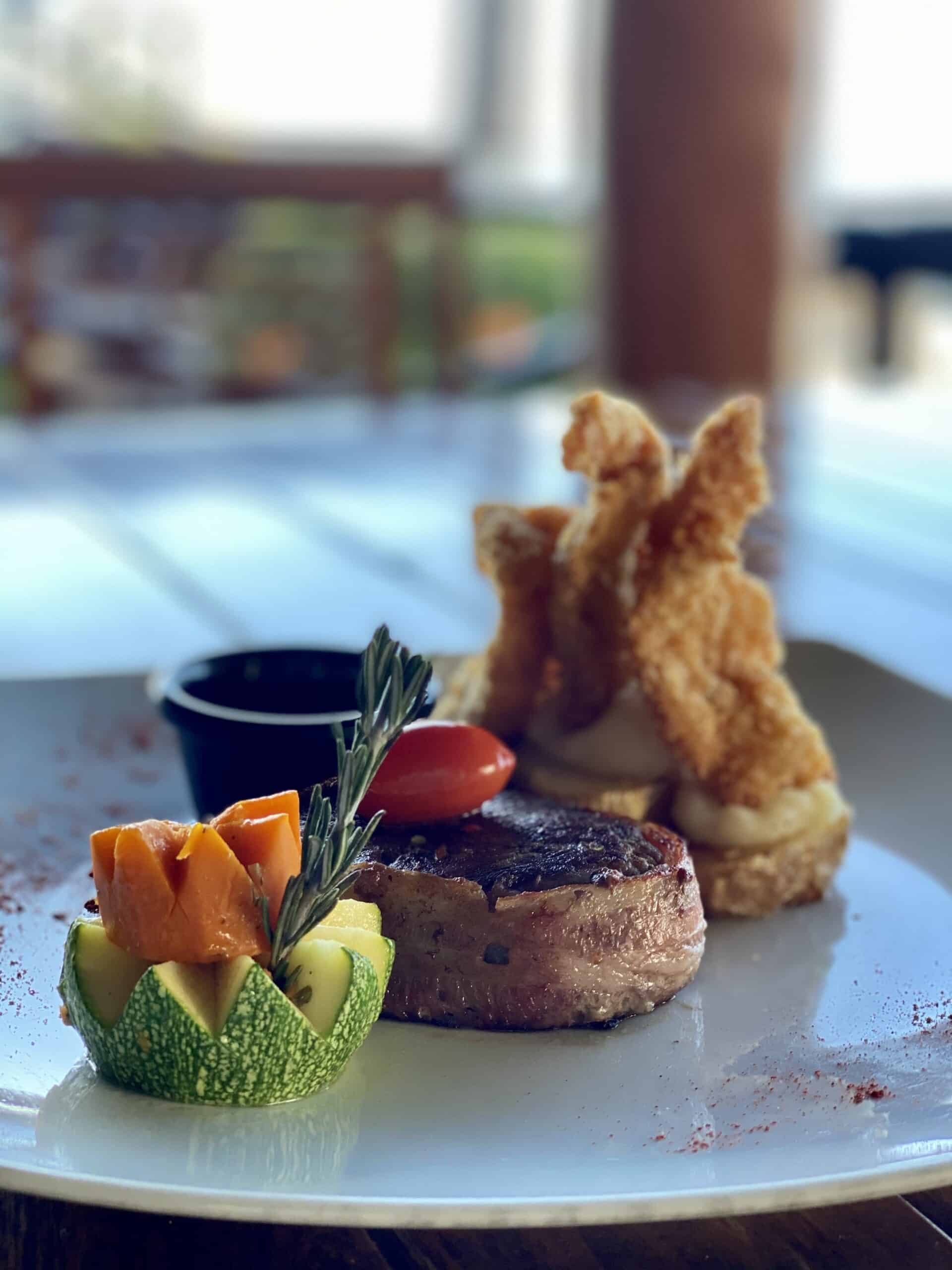 Gourmet dish featuring steak and fried shrimp.