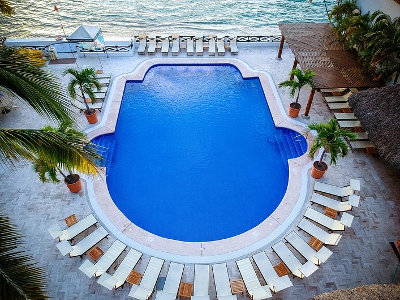 Aerial view of the pool with lounge chairs in front of the beach.