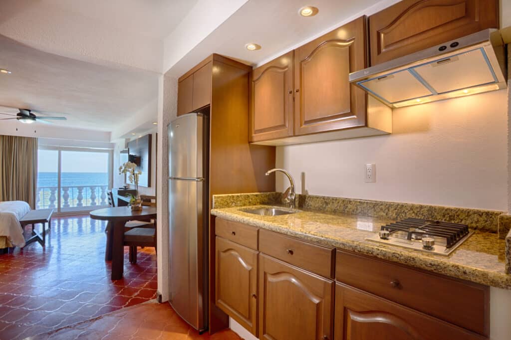 Kitchenette with granite countertops, ocean view in background.