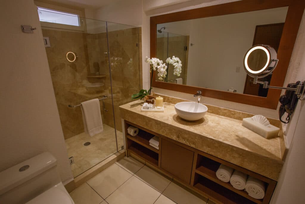 Elegant bathroom with a large mirror and glass shower.