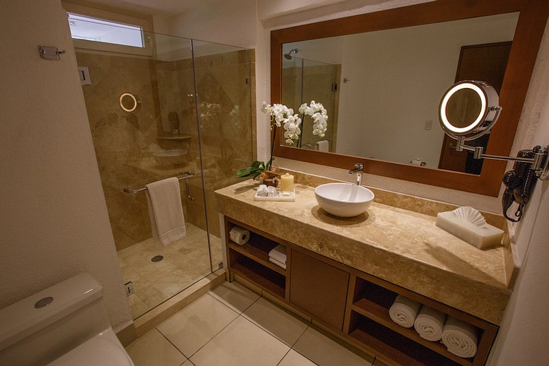 Bathroom with one sink and large mirror and walk-in shower.