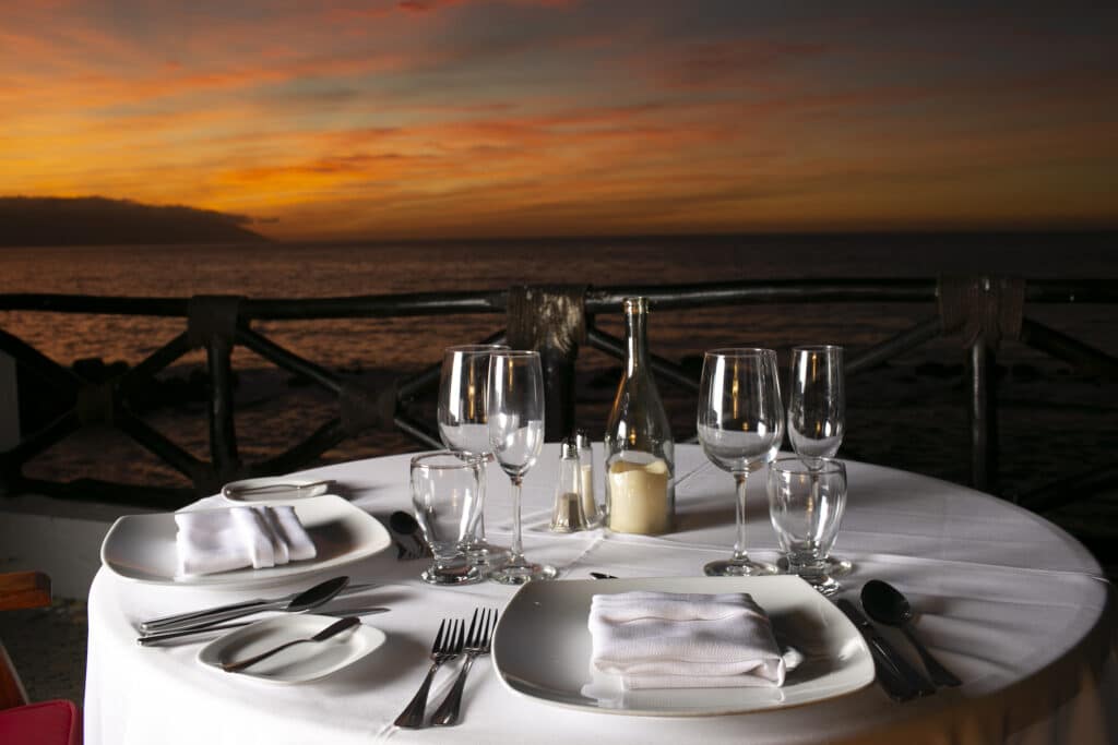 Romantic sunset dinner setup by the ocean.