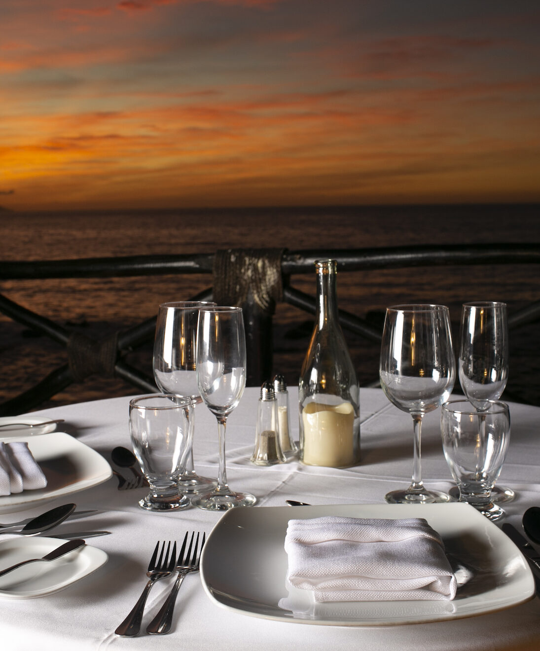 Romantic sunset dinner setup by the ocean.