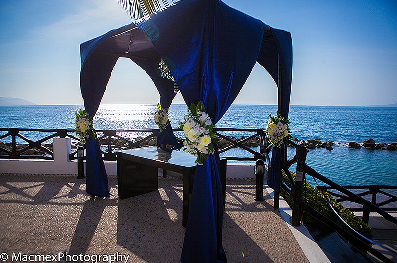 Blue cabana alter with chandelier with ocean views in the background.