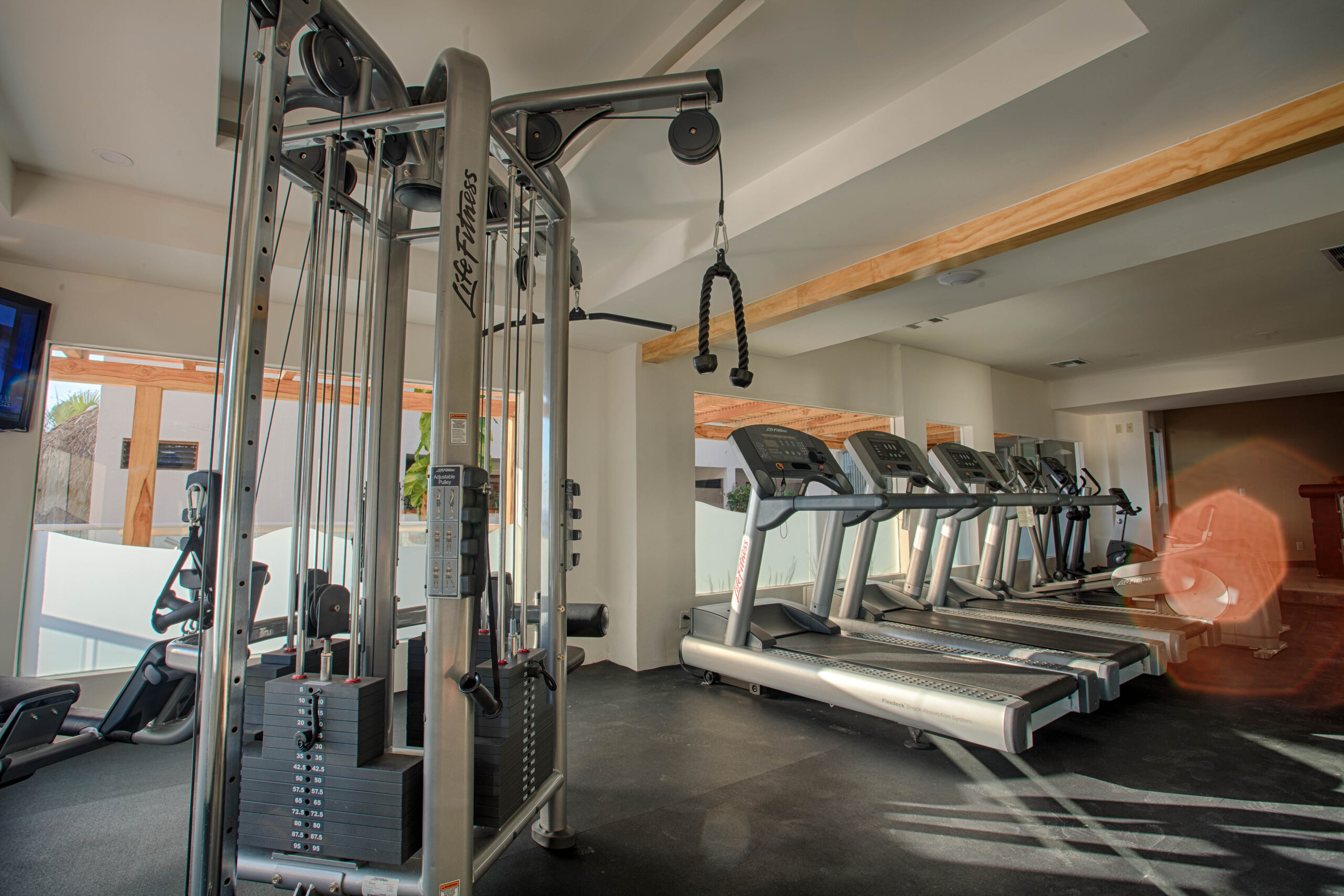 Hotel gym equipment featuring various treadmills and a lat pull down machine.