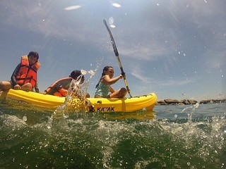 Close up view of three people kayaking and splashing water.