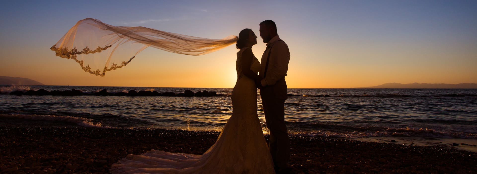 Couple embracing on the beach during sunset.