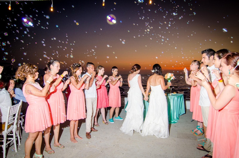 Wedding ceremony with bubbles at sunset on the beach.