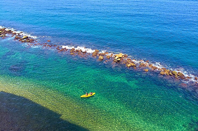 Two people kayaking together in clear waters.